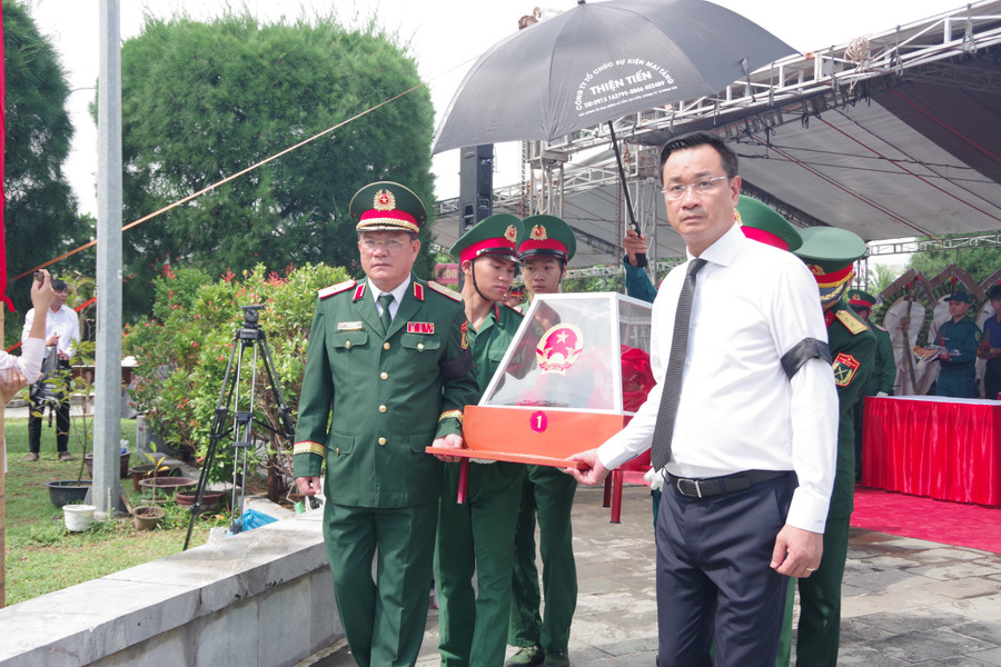 Ông Lê Ngọc Quang (áo trắng), Bí thư Thành ủy Đà Nẵng đưa các hài cốt liệt sĩ đi an táng. Ảnh: Quang Cường, Bộ CHQS Đà Nẵng